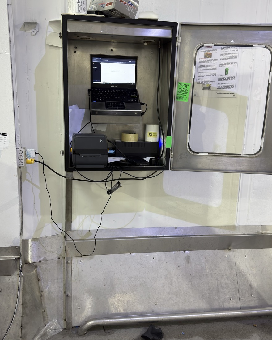 Estación de registro con computador e impresora térmica montada en gabinete de acero dentro de la cámara de frío